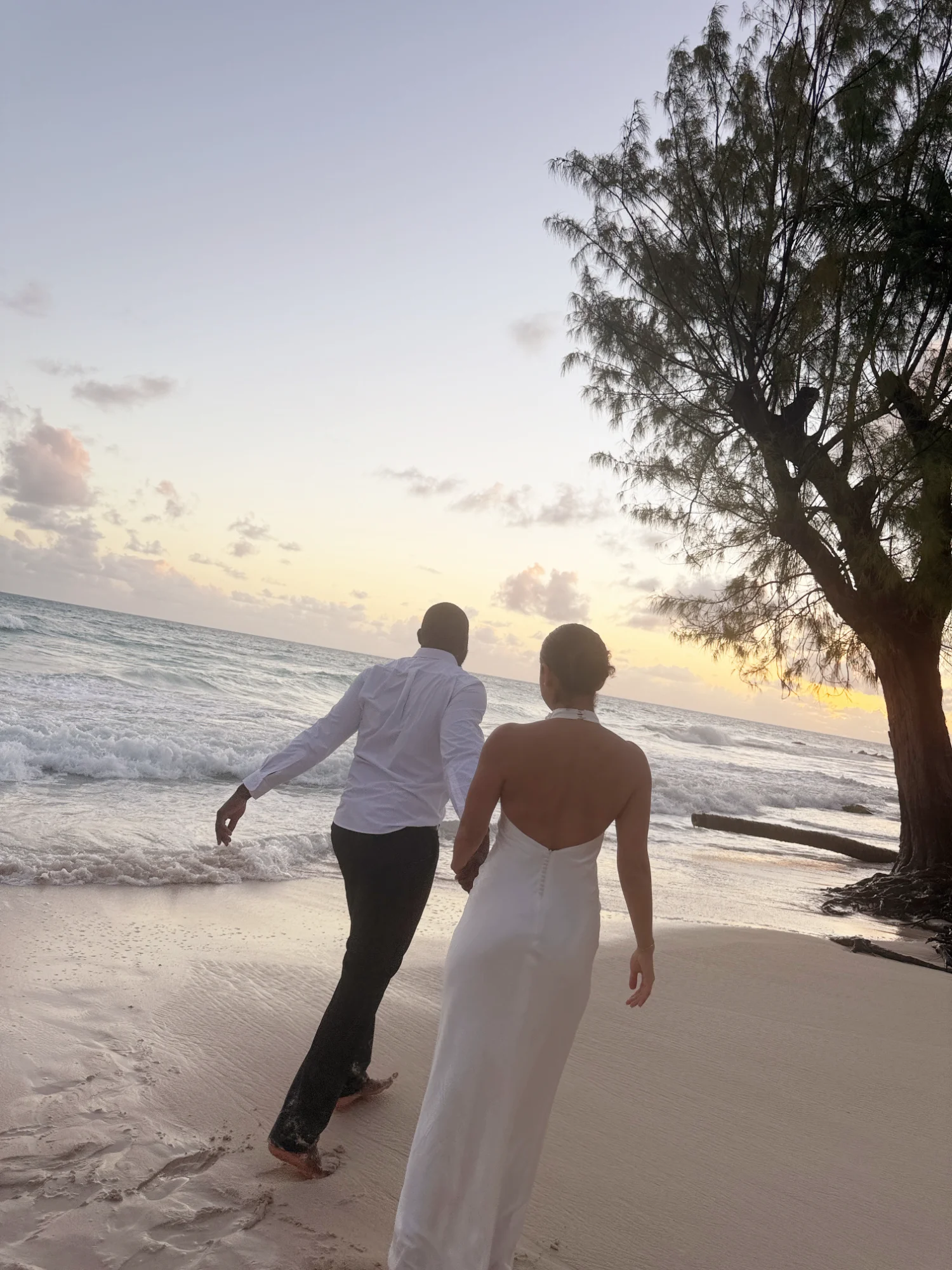 Couple walking together on beach at sunset